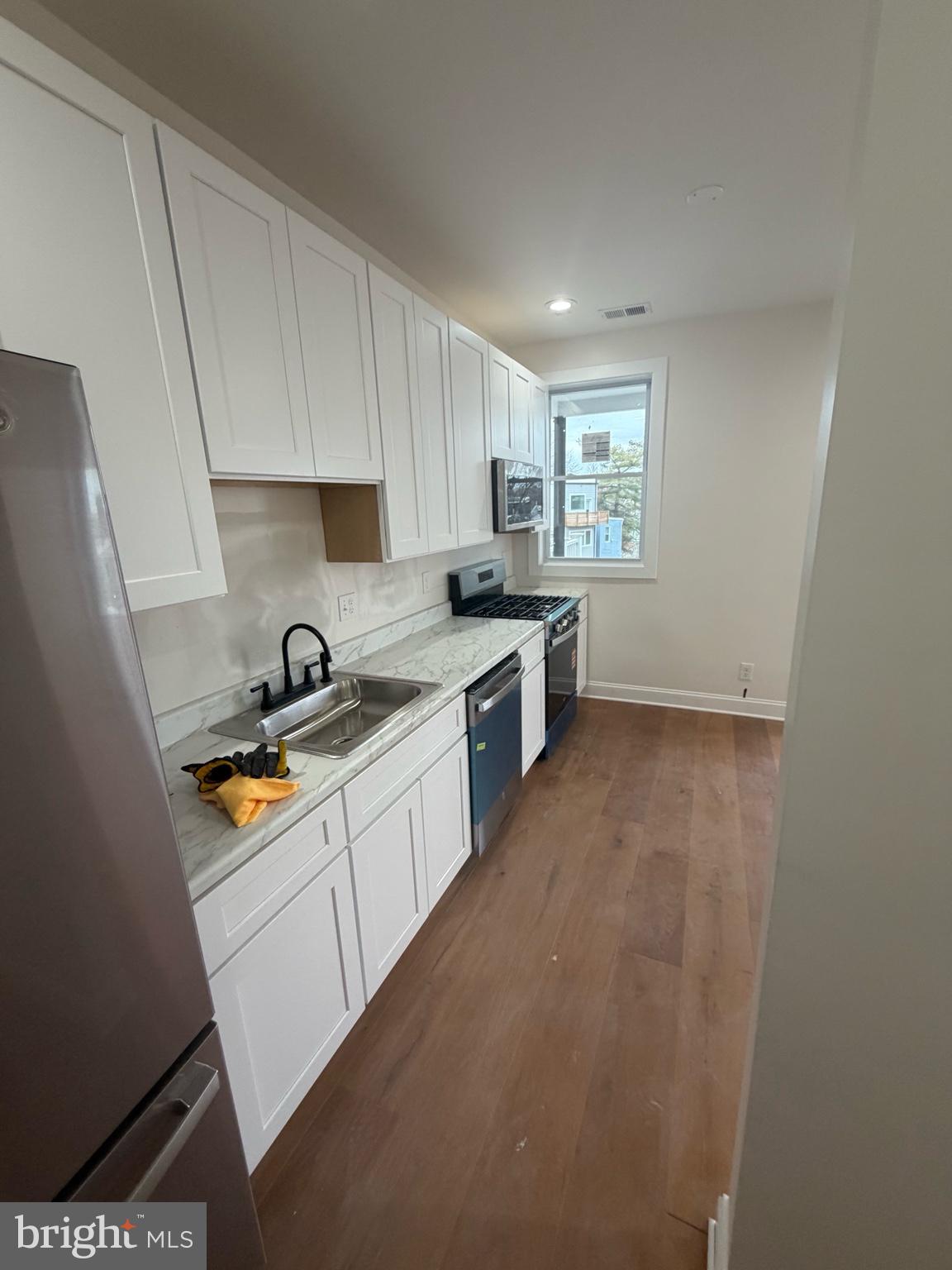 1224 Maryland Avenue Northeast, Unit 4 Washington, DC 20002 - Photo 3 of 11 a kitchen with a sink a stove cabinets and a window