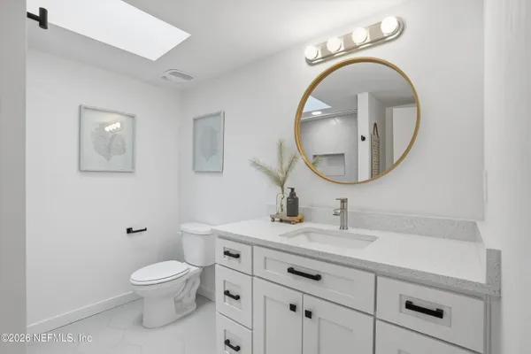 a bathroom with a toilet a sink and mirror