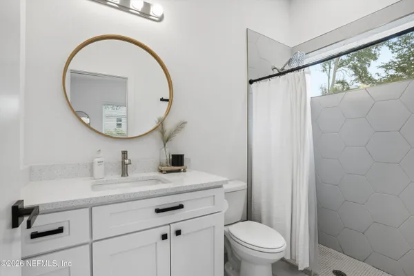 a bathroom with a sink a toilet and a mirror