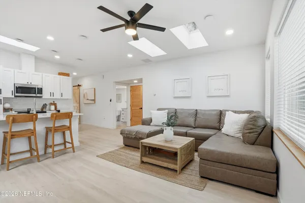 a living room with furniture and kitchen view