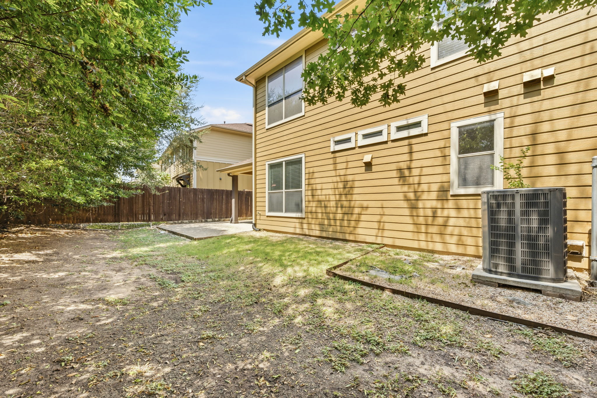 6708 Manchaca Road, Unit 4 Austin, TX 78745 - Photo 24 of 25 Mature trees shade a quiet backyard bordered by a wooden privacy fence.