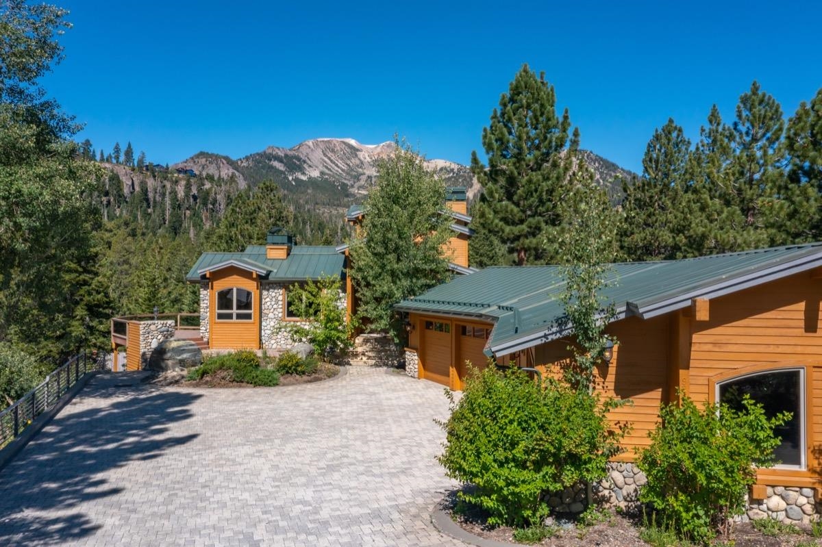 92 Garnet Street Mammoth Lakes, CA 93546 - Photo 1 of 50 View of front of home featuring a metal roof, a mountain view, a garage, and stone siding