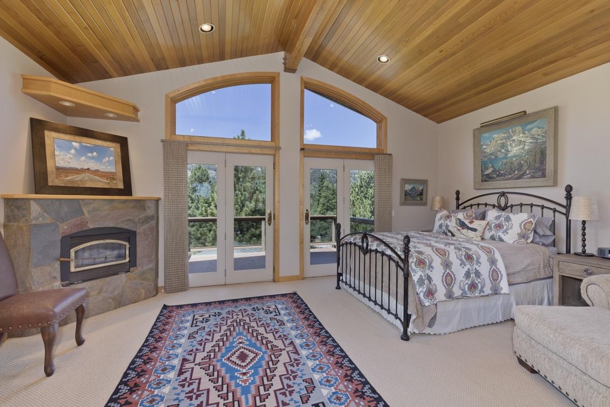 92 Garnet Street Mammoth Lakes, CA 93546 - Photo 20 of 50 Bedroom with french doors, access to outside, a tiled fireplace, a wooden ceiling with exposed beams
