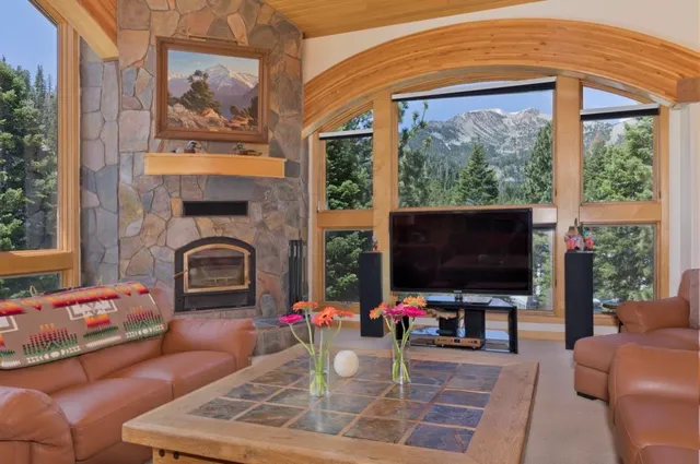 a living room with furniture a flat screen tv and a floor to ceiling window