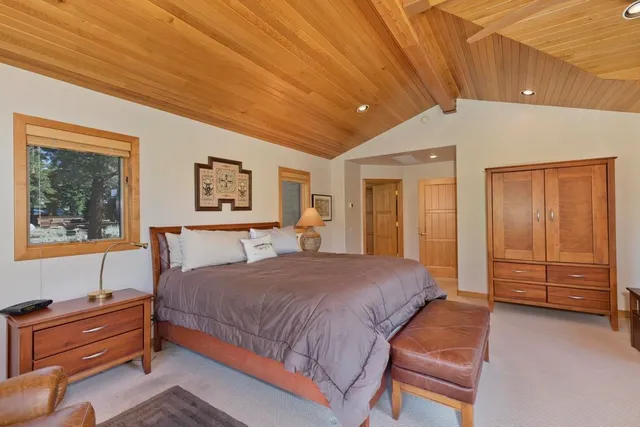 a bedroom with a bed and a dresser next to a window