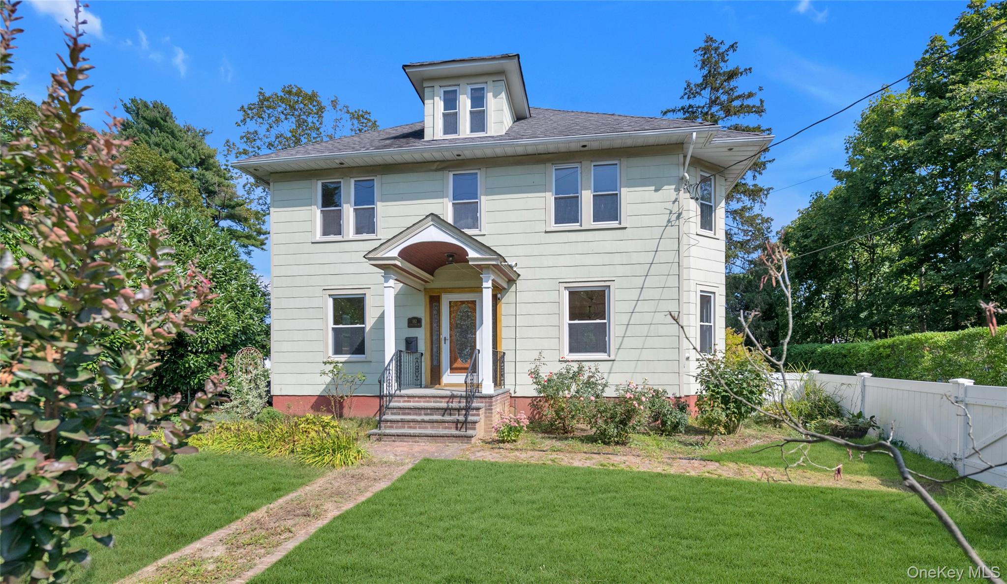 American foursquare style home with roof with shingles