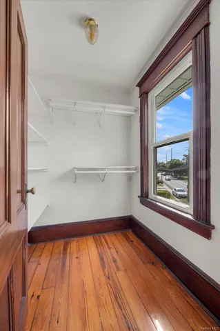 a view of a room with wooden floor and small window