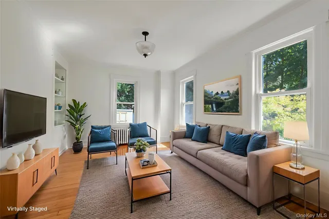 a living room with furniture a flat screen tv and a large window