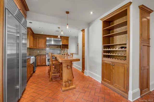 a kitchen with stainless steel appliances kitchen island granite countertop a refrigerator and a stove top oven