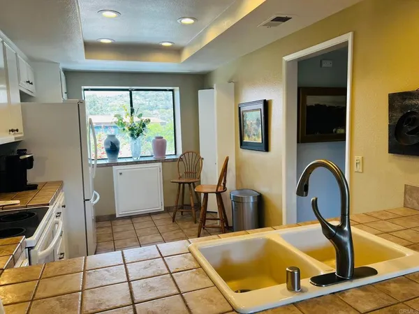 a view of a kitchen with a sink and living room view