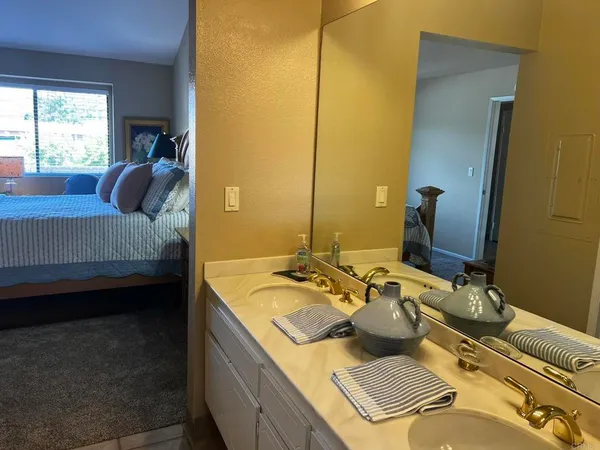 a bedroom with a bed and a flat tv screen on dresser