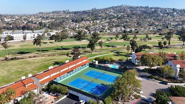 an aerial view of residential houses with outdoor space and swimming pool