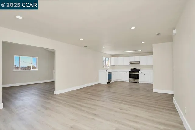 a kitchen with granite countertop a stove top oven and cabinets