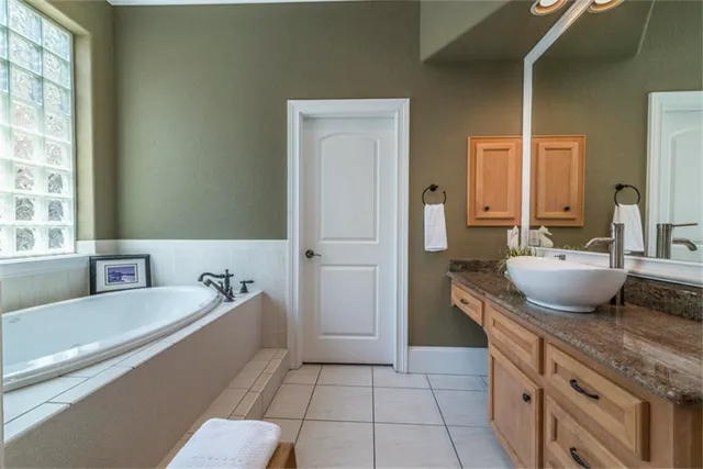a spacious bathroom with a tub sink and mirror