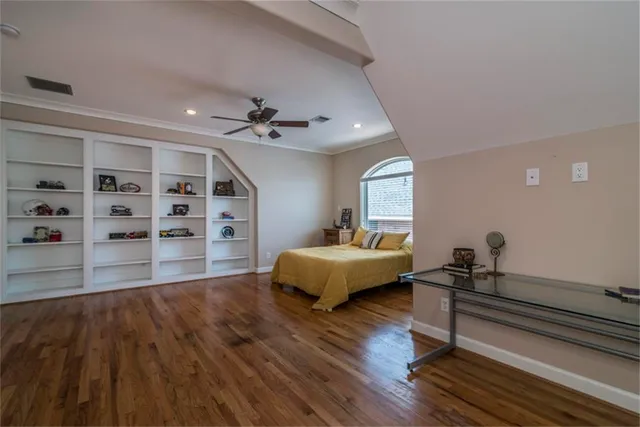 a spacious bedroom with a bed and a wooden floor