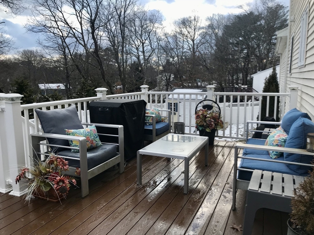 28 Ely Street Randolph, MA 02368 - Photo 23 of 28 a view of a deck with couches table and chairs with wooden floor