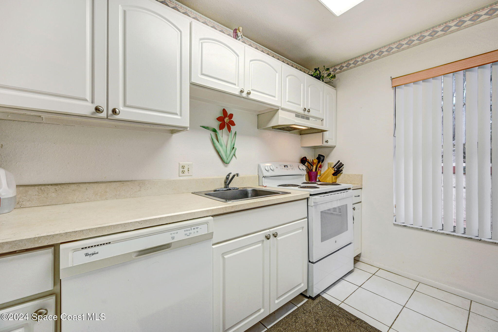 815 Brae Court Northeast Palm Bay, FL 32905 - Photo 6 of 21 a kitchen with white cabinets and sink