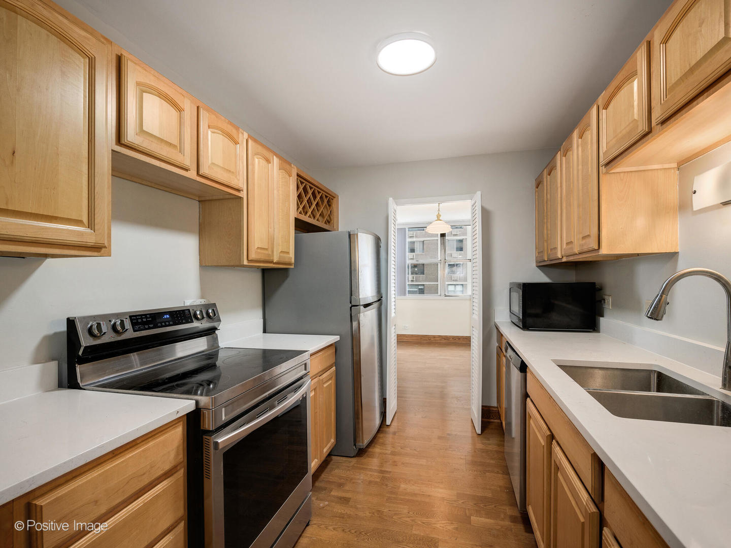 6301 North Sheridan Road, Unit 14O Chicago, IL 60660 - Photo 4 of 22 a kitchen with a sink a stove top oven and refrigerator