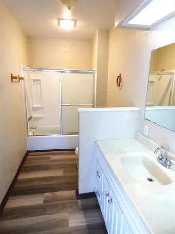 a bathroom with a double vanity sink a mirror and a bathtub