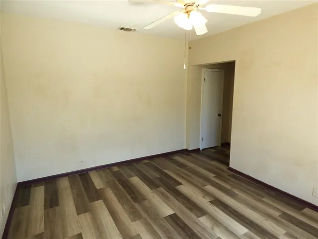 a view of an empty room with a chandelier fan