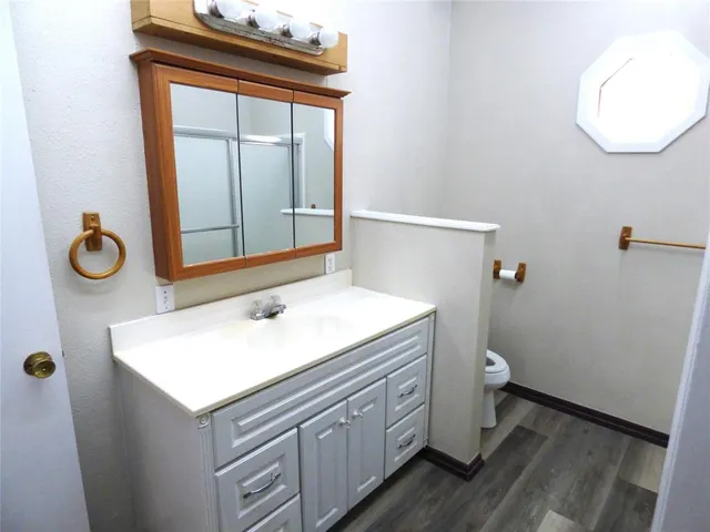 a bathroom with a sink a toilet and mirror
