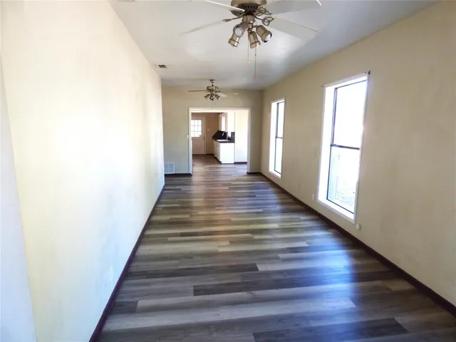 a view of a hallway with wooden floor and staircase