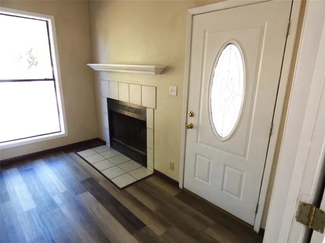 a view of a livingroom with wooden floor and a fireplace