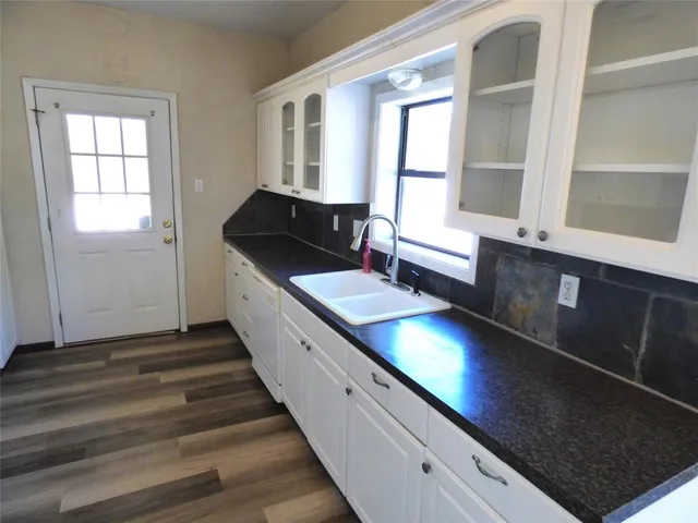 a kitchen with granite countertop stainless steel appliances sink stove and cabinets
