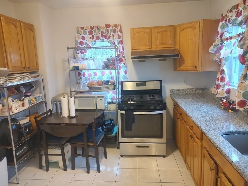 378 Ferry Street Everett, MA 02149 - Photo 12 of 26 a kitchen with stainless steel appliances granite countertop a stove and a refrigerator