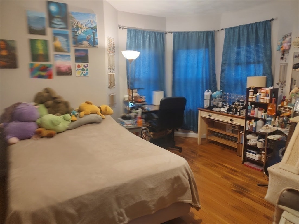 378 Ferry Street Everett, MA 02149 - Photo 14 of 26 a bedroom with a bed and wooden furniture