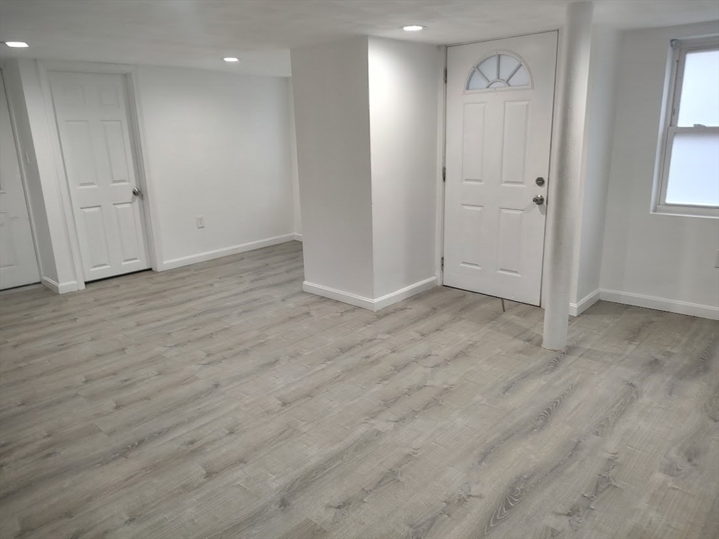 378 Ferry Street Everett, MA 02149 - Photo 21 of 26 an empty room with wooden floor and windows