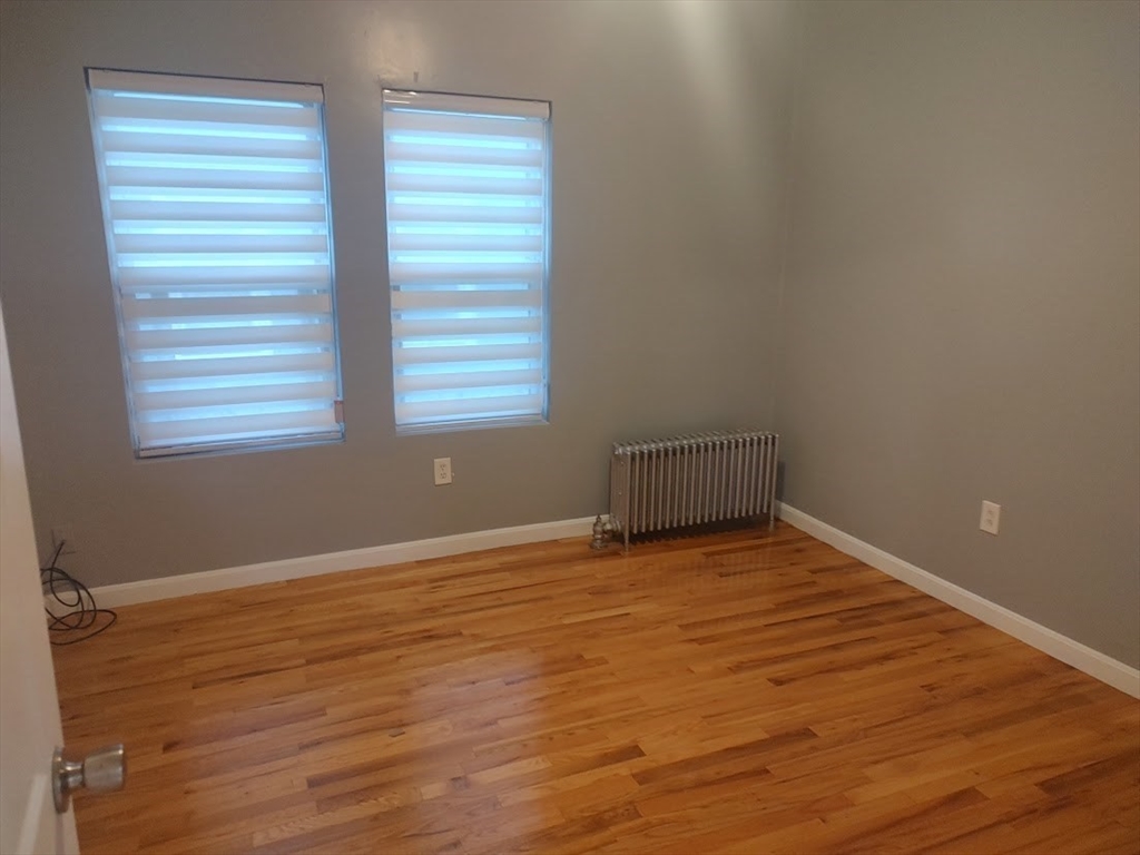 378 Ferry Street Everett, MA 02149 - Photo 5 of 26 a view of an empty room with wooden floor and a window
