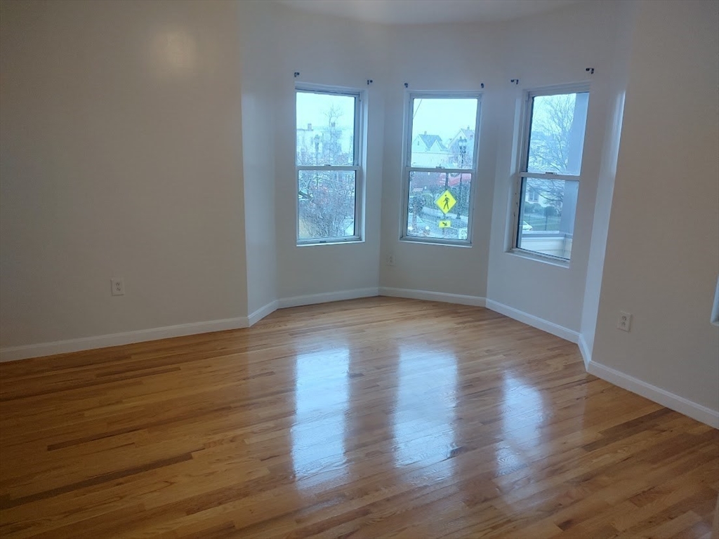 378 Ferry Street Everett, MA 02149 - Photo 9 of 26 an empty room with wooden floor and windows