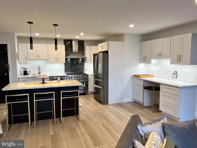 a kitchen with kitchen island a sink stainless steel appliances and cabinets
