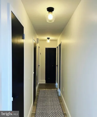 a view of a hallway with wooden floor