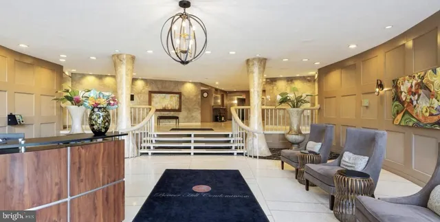 a living room with furniture a clock and a chandelier