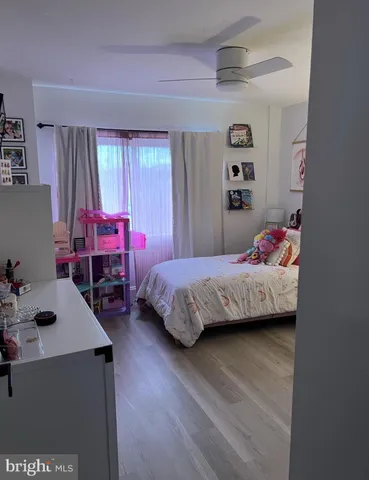 a bedroom with a bed a dresser and a window