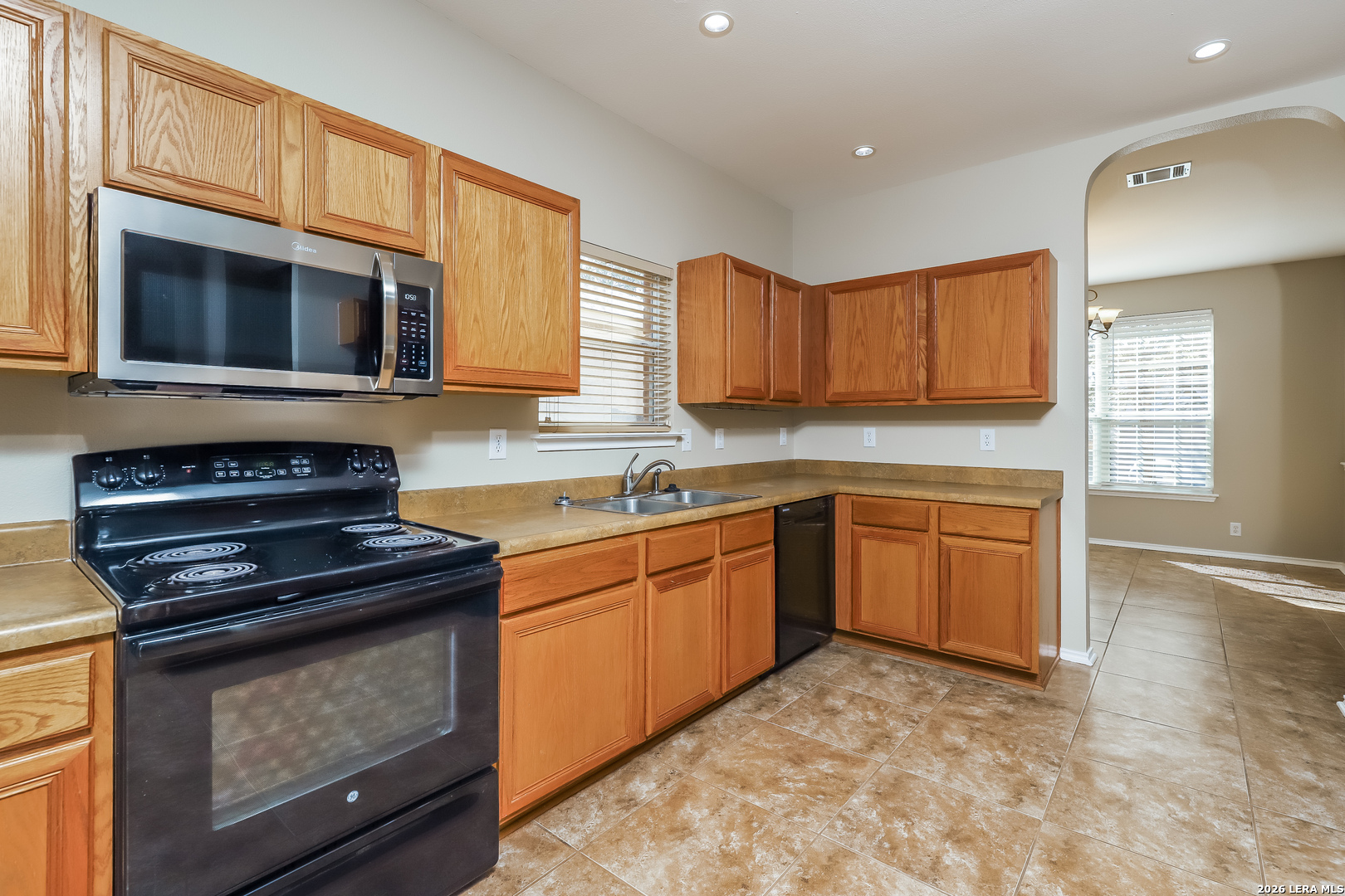8611 Tioga Pass Helotes, TX 78023 - Photo 3 of 14 a kitchen with stainless steel appliances granite countertop a stove a sink and a microwave