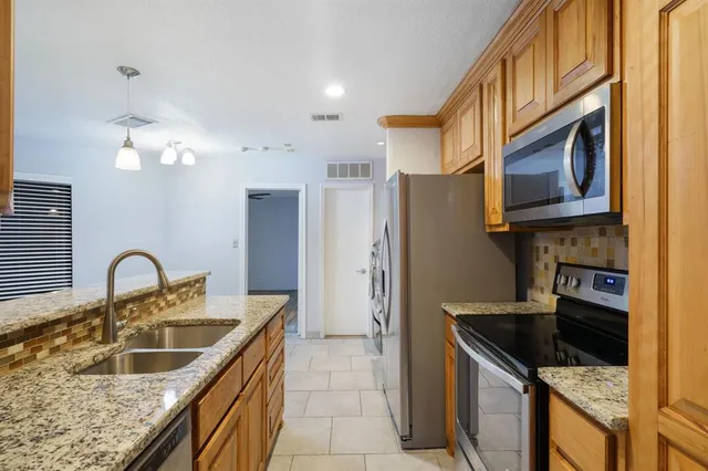 a kitchen with stainless steel appliances granite countertop a sink stove and refrigerator