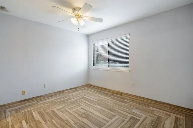 a view of a room with a ceiling fan and a window