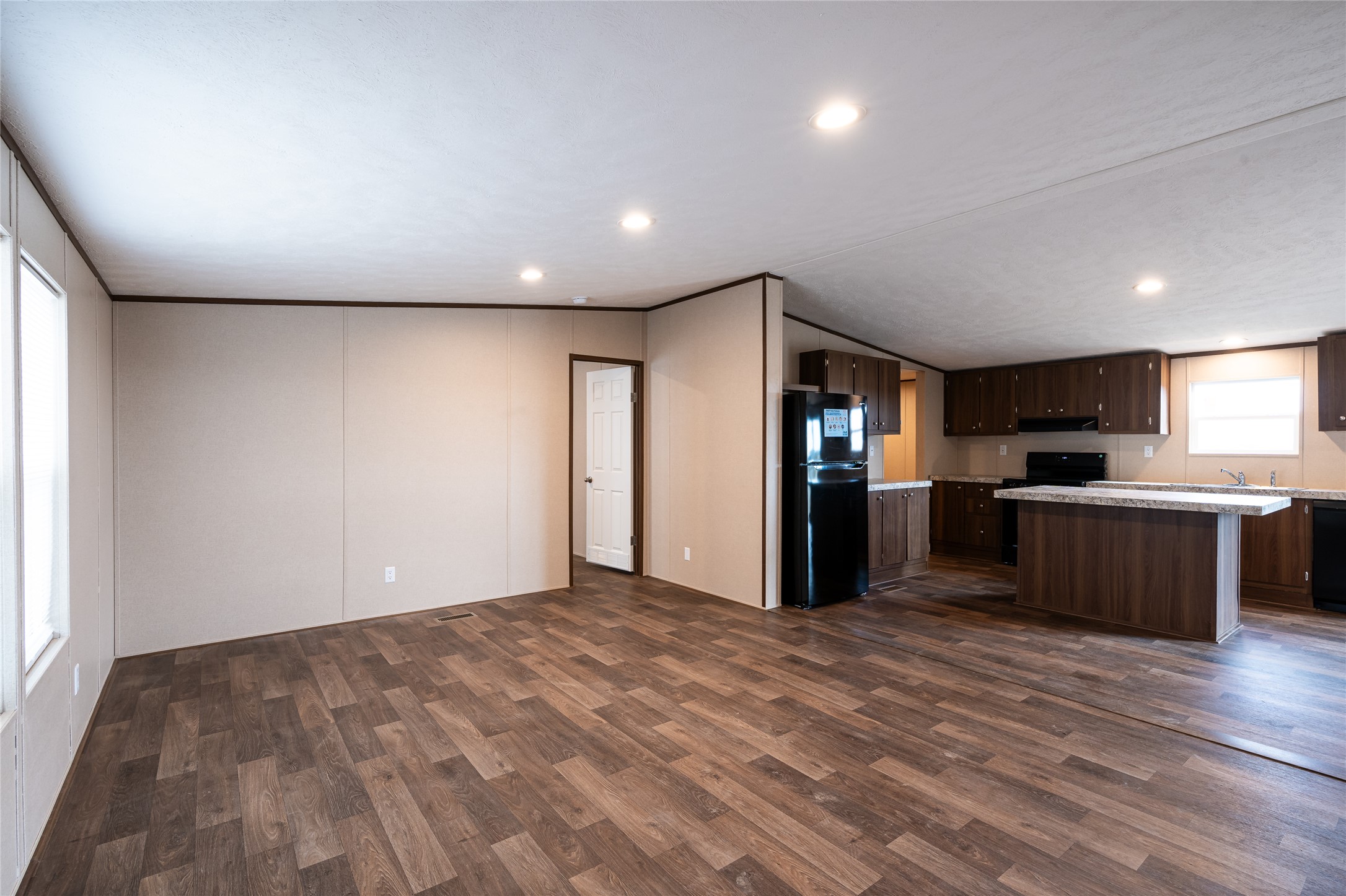 6945 Seawillow Road Lockhart, TX 78644 - Photo 3 of 21 a view of a kitchen with kitchen island wooden floor center island and stainless steel appliances