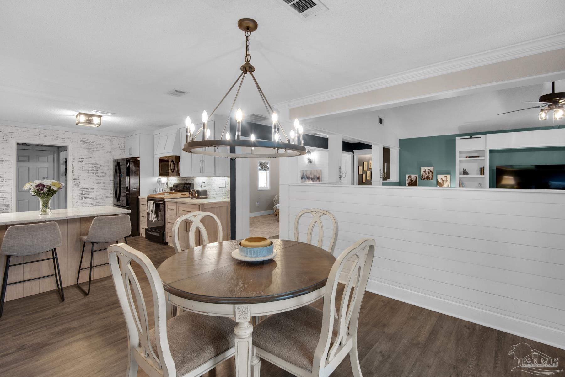 4316 Highland Boulevard Pace, FL 32571 - Photo 20 of 43 a view of a dining room with furniture and wooden floor