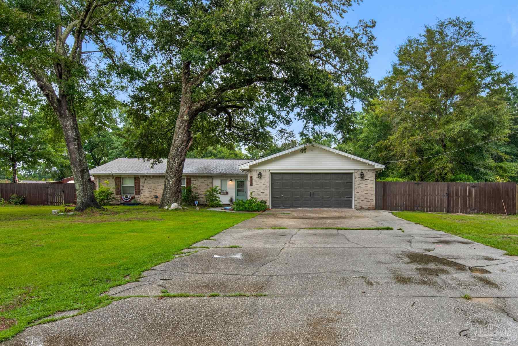4316 Highland Boulevard Pace, FL 32571 - Photo 2 of 43 a front view of a house with a yard and trees