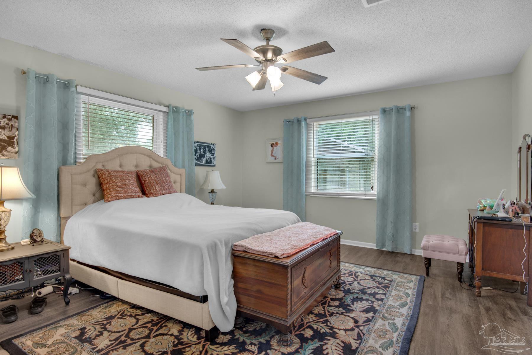4316 Highland Boulevard Pace, FL 32571 - Photo 21 of 43 a bedroom with a bed and wooden floor