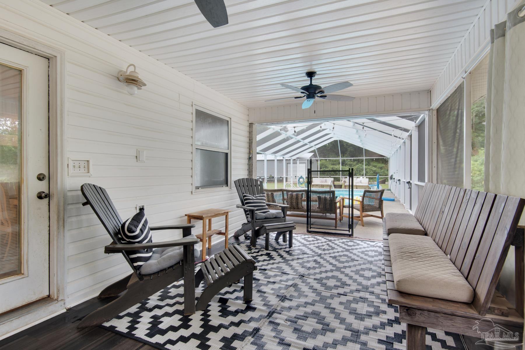 4316 Highland Boulevard Pace, FL 32571 - Photo 34 of 43 a living room with furniture a rug and a chandelier
