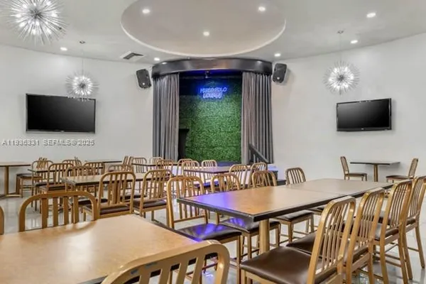 a very nice looking dining room with kitchen island furniture a chandelier and a large window