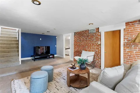a living room with furniture a flat screen tv and a window