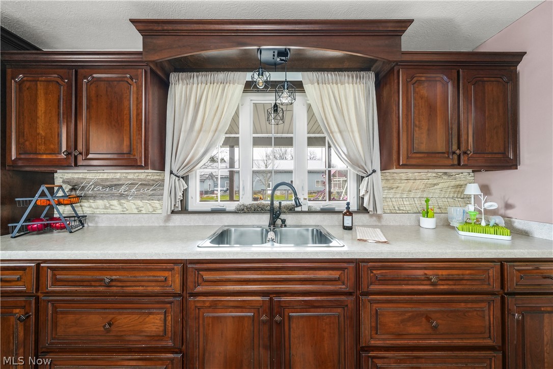 9561 Creaser Road North Bloomfield, OH 44450 - Photo 4 of 45 Kitchen with light countertops, a textured ceiling, and backsplash