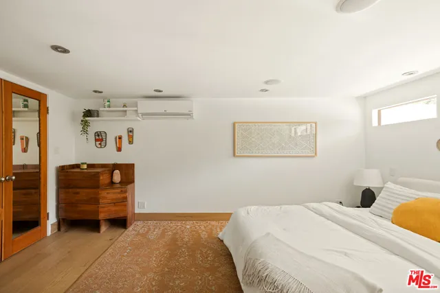 a bedroom with a bed and painting on the wall