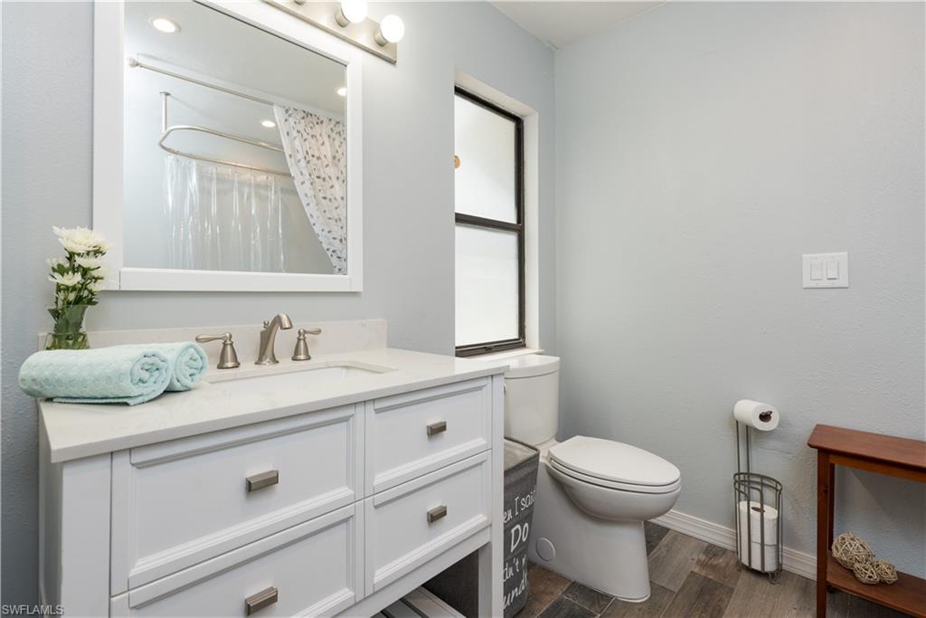 17401 Butler Road Fort Myers, FL 33967 - Photo 13 of 22 a bathroom with a granite countertop toilet sink and mirror